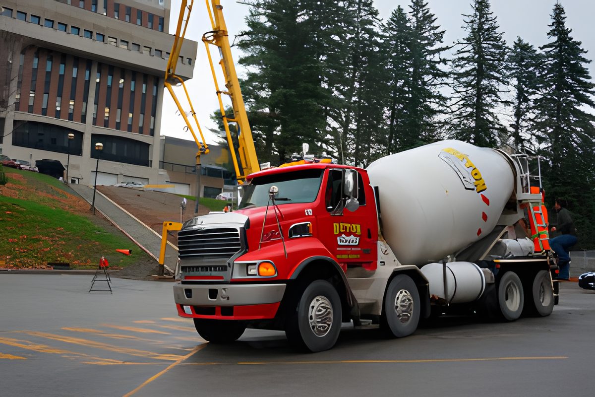 Un trottoir de béton frais le long du stationnement du CEGEP de Sherbrooke, protégé par des piquets et un ruban