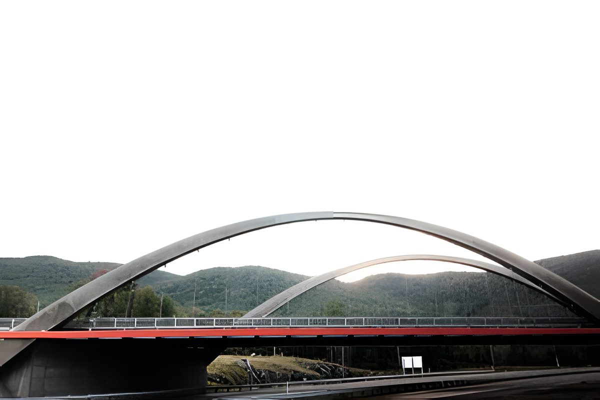 Un pont en arche au-dessus d'une rivière, les câbles de suspension, les montagnes derrière